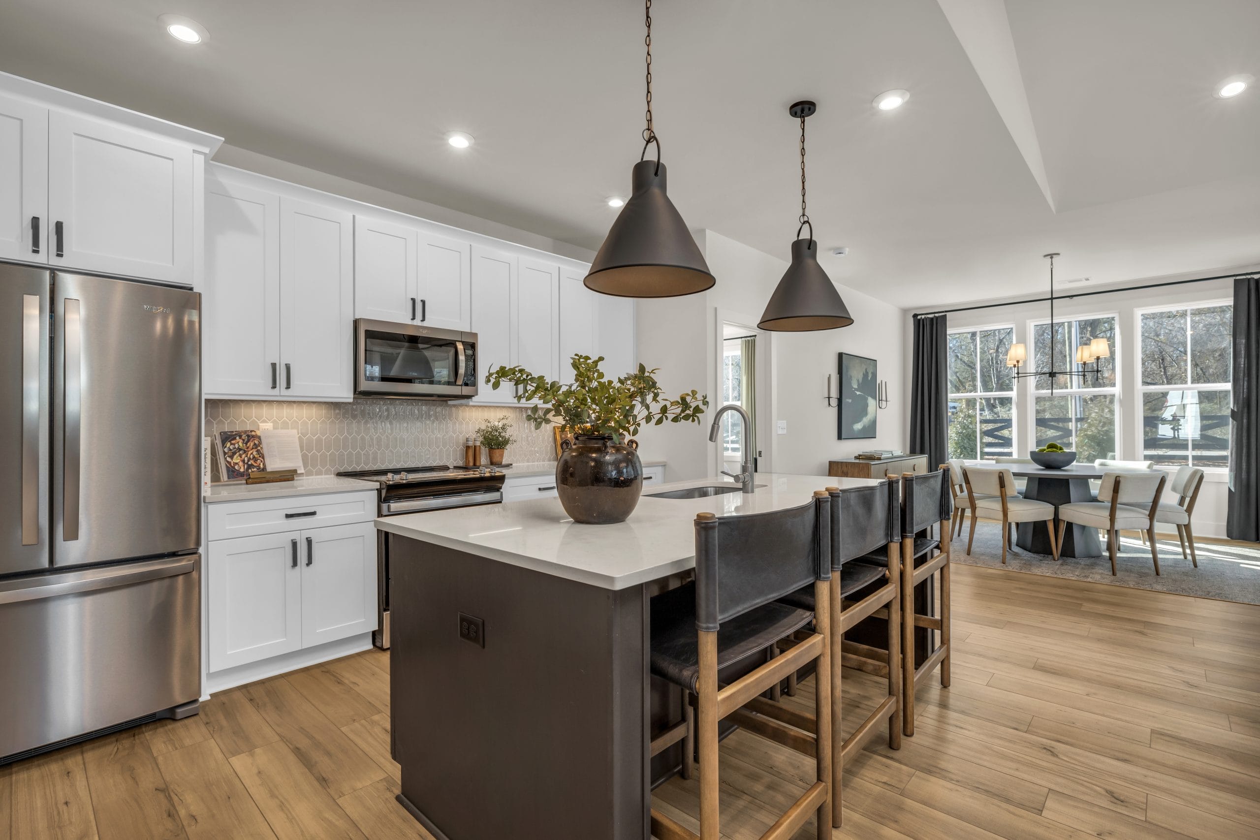 Kitchen with white cabinets, island, and dining area.