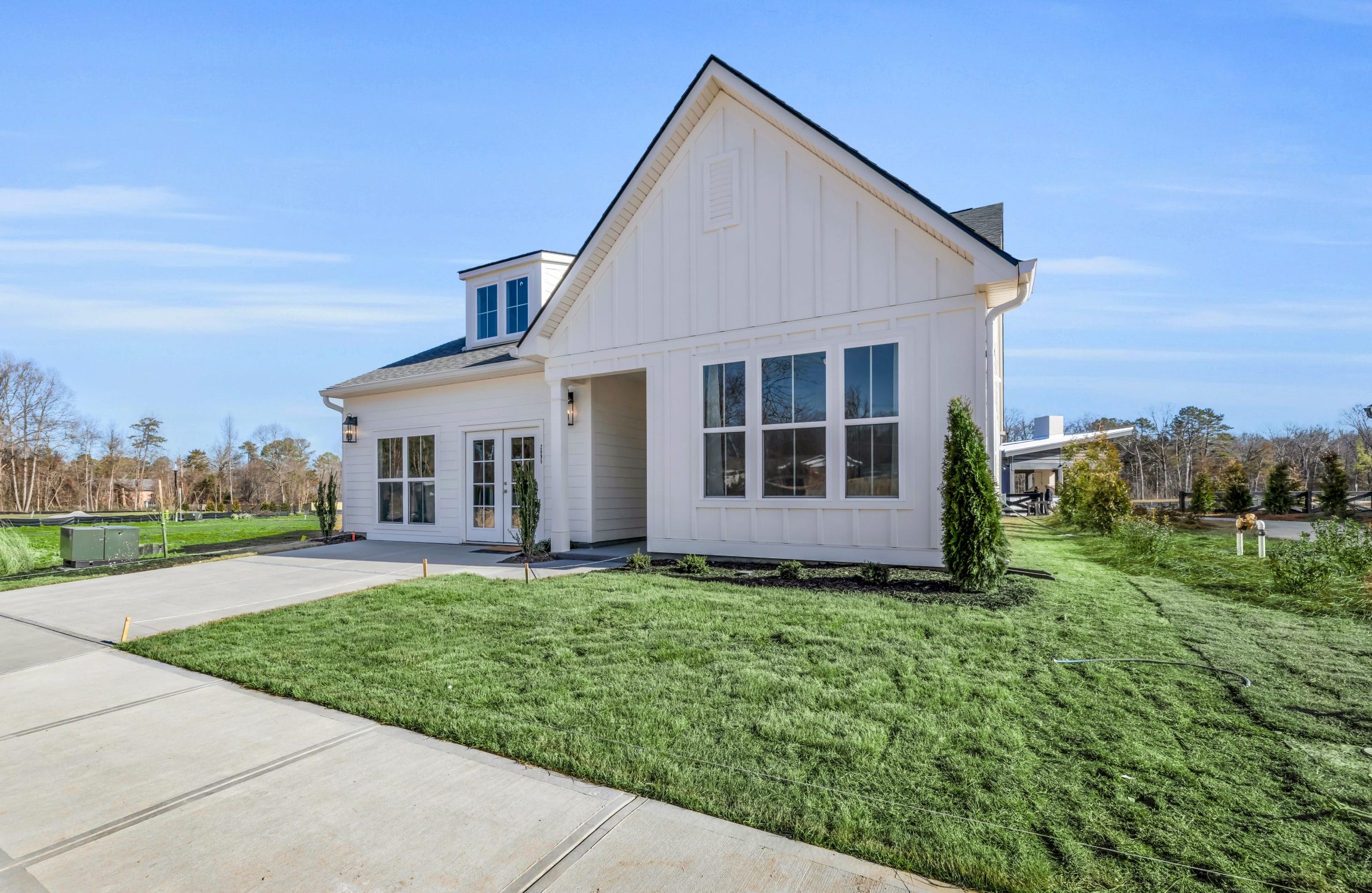 Single-story house with gabled roof, large windows, and well-maintained lawn.