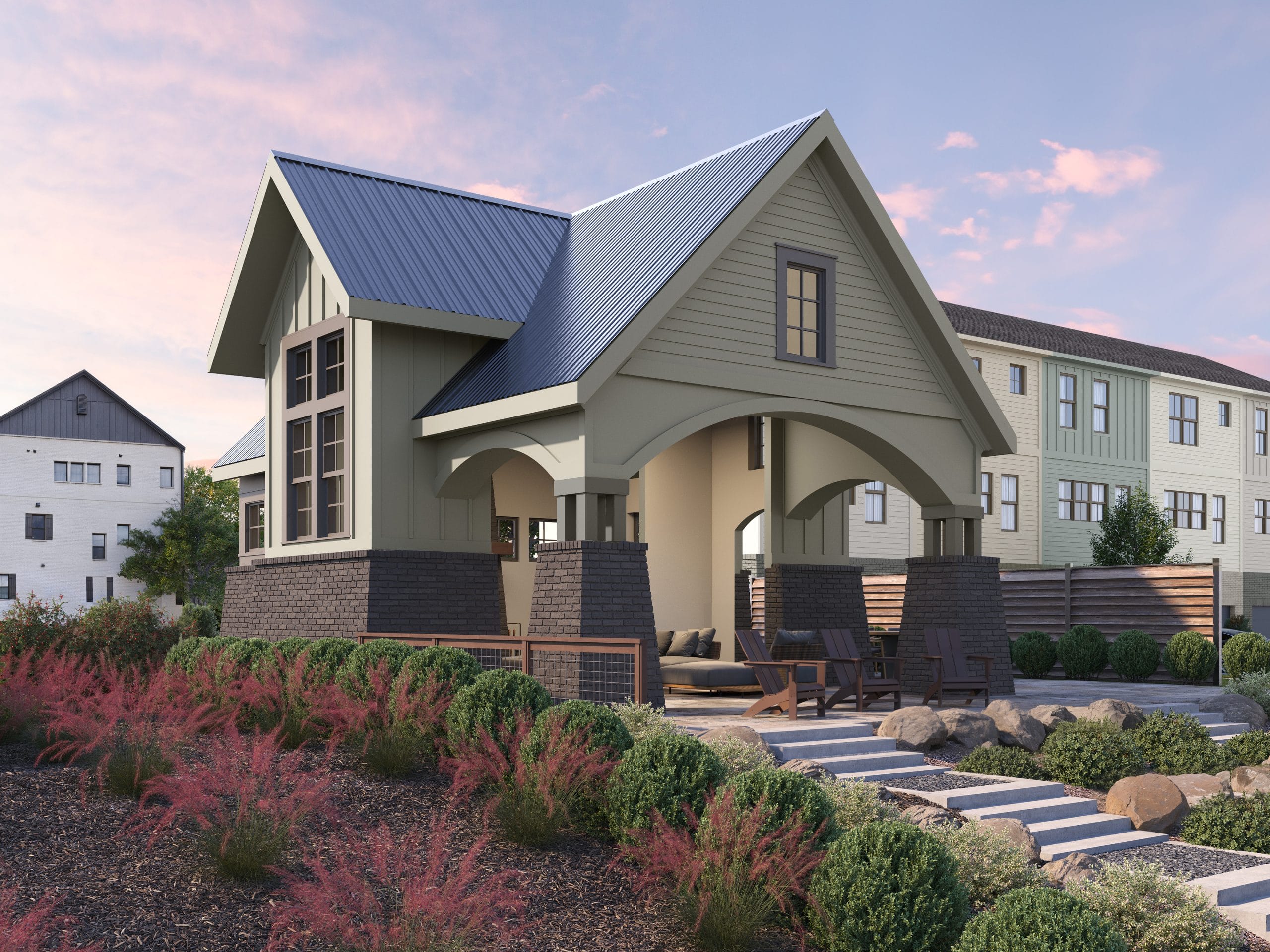 New house with gabled roof, large windows, light green siding, dark brick accents, outdoor seating area, landscaped gardens, residential neighborhood, partly cloudy sky with pink hues.